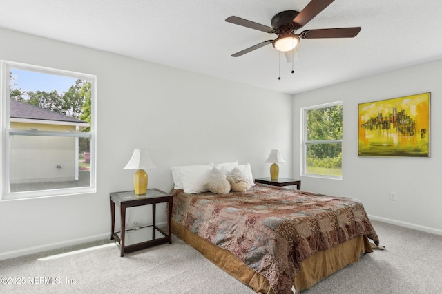 bedroom with light carpet, baseboards, and a ceiling fan
