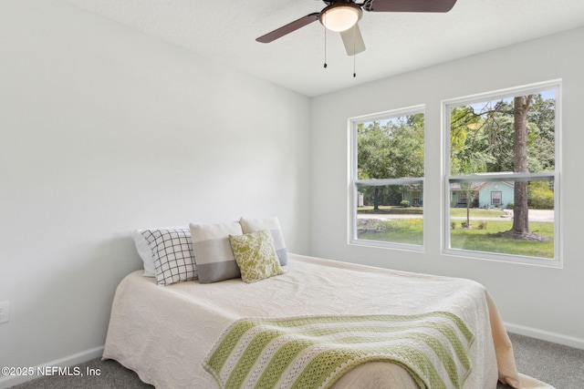 carpeted bedroom with baseboards and ceiling fan