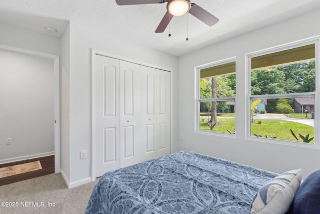 bedroom with carpet flooring, a closet, baseboards, and ceiling fan