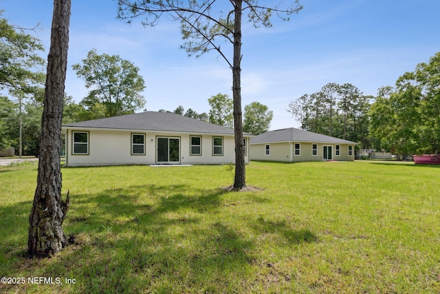 back of house featuring a yard and stucco siding
