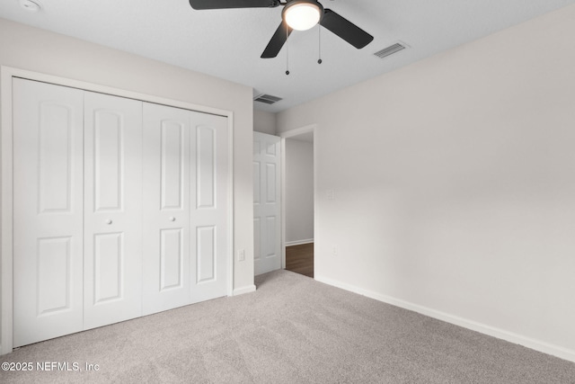 unfurnished bedroom featuring carpet flooring, a closet, baseboards, and a ceiling fan