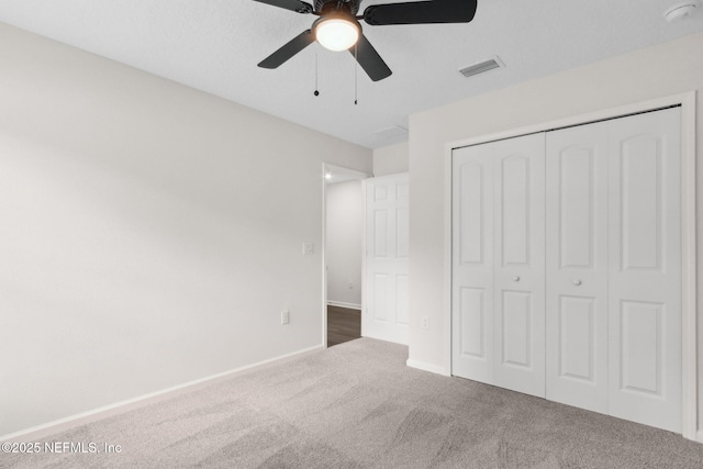 unfurnished bedroom with carpet, a closet, a ceiling fan, and baseboards