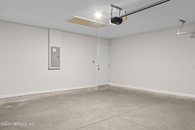 garage featuring electric panel, a garage door opener, and baseboards