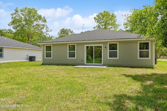 back of property featuring a patio area, a yard, central AC unit, stucco siding, and roof with shingles