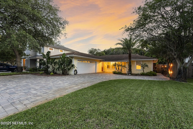 view of front of home with decorative driveway, a garage, and stucco siding