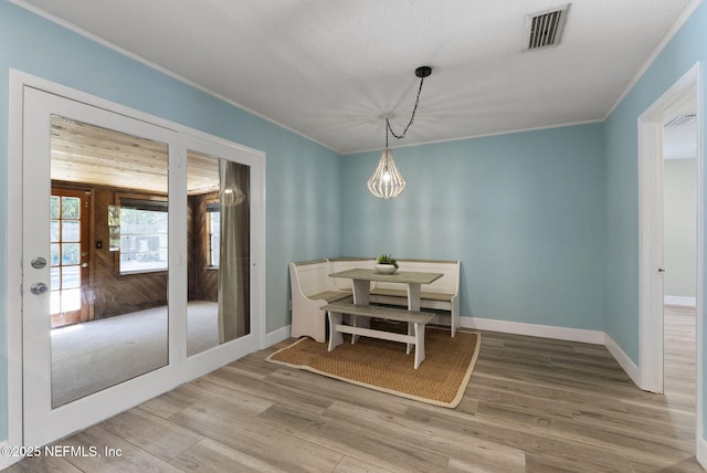 dining space featuring ornamental molding, wood finished floors, baseboards, and a chandelier