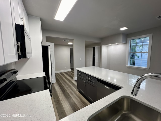 3133 Gilmore St, Jacksonville, FL 32205 - kitchen with stainless steel appliances, a sink, white cabinets, wood finished floors, and light stone counters