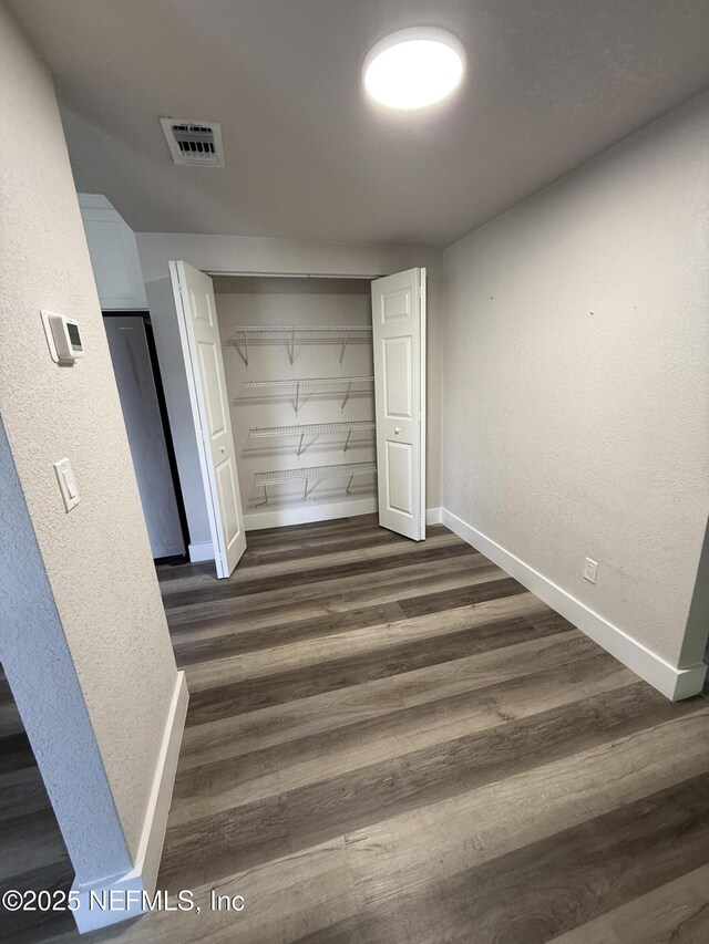 3133 Gilmore St, Jacksonville, FL 32205 - unfurnished bedroom with baseboards, dark wood finished floors, a closet, and a textured wall