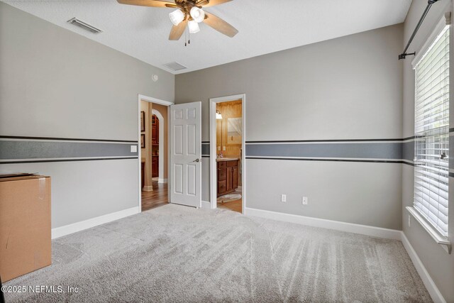 400 N Landguard Rd, Saint Augustine, FL 32092 - unfurnished bedroom with carpet floors, baseboards, connected bathroom, and ceiling fan