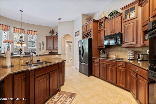 400 N Landguard Rd, Saint Augustine, FL 32092 - kitchen with stainless steel fridge, black microwave, a sink, backsplash, and a textured ceiling