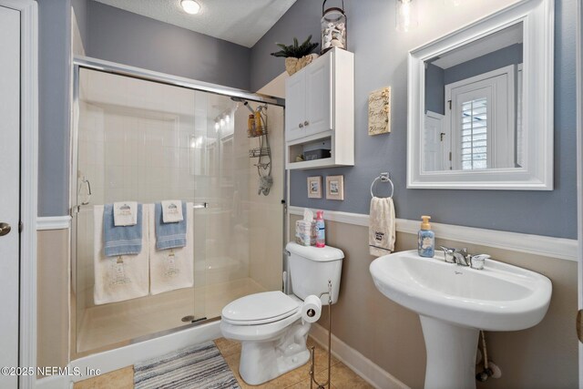 400 N Landguard Rd, Saint Augustine, FL 32092 - bathroom featuring toilet, a stall shower, tile patterned flooring, and baseboards