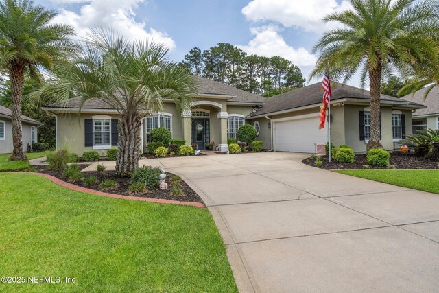 400 N Landguard Rd, Saint Augustine, FL 32092 - view of front of home with stucco siding, a garage, concrete driveway, and a front lawn