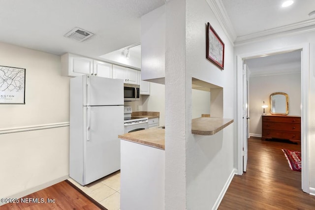 100 Fairway Park Blvd Unit 802, Ponte Vedra, FL 32082 - kitchen with white appliances, white cabinetry, crown molding, light wood-style floors, and baseboards