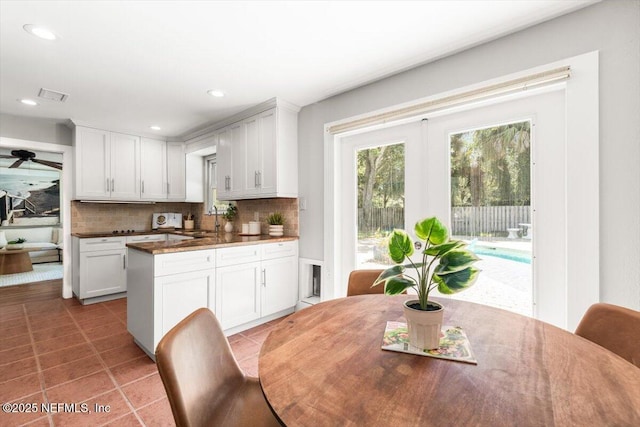 1659 Sea Oats Dr, Atlantic Beach, FL 32233 - kitchen with backsplash, white cabinetry, a sink, dark countertops, and recessed lighting