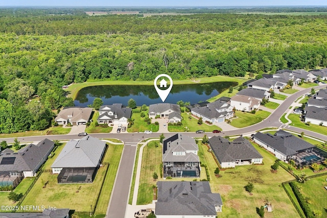 aerial overview of property's location featuring a forest, a nearby body of water, and nearby suburban area