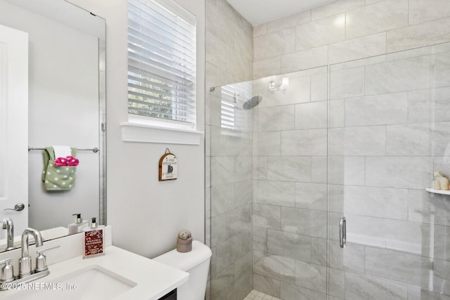 bathroom with a stall shower, toilet, and vanity