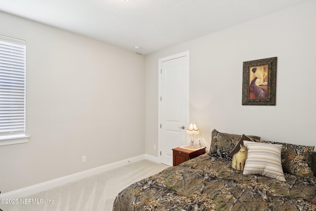 bedroom with light carpet and baseboards