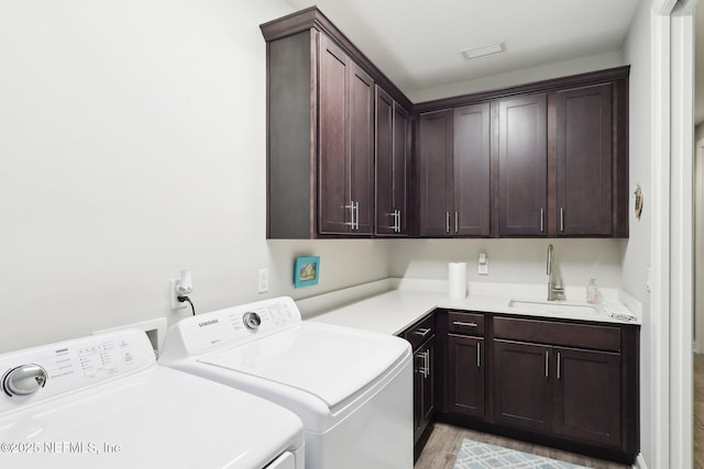 laundry area with cabinet space, independent washer and dryer, and light wood finished floors