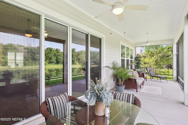 sunroom featuring a ceiling fan and outdoor dining area