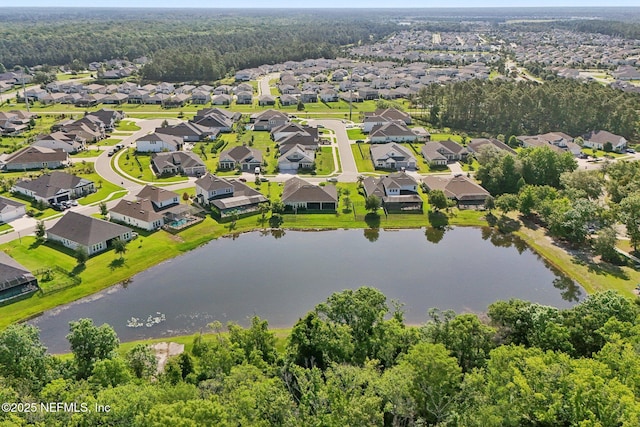 aerial view of residential area with a nearby body of water and a heavily wooded area