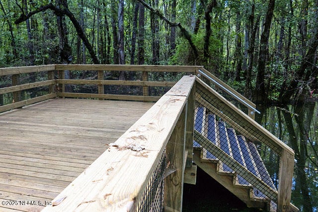 wooden terrace featuring a view of trees