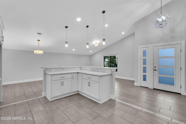 2032 Sandpiper Pt, Neptune Beach, FL 32266 - kitchen featuring white cabinetry, pendant lighting, a kitchen island, light stone countertops, and high vaulted ceiling