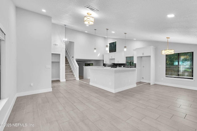 2032 Sandpiper Pt, Neptune Beach, FL 32266 - kitchen featuring white cabinetry, a textured ceiling, open floor plan, recessed lighting, and hanging light fixtures