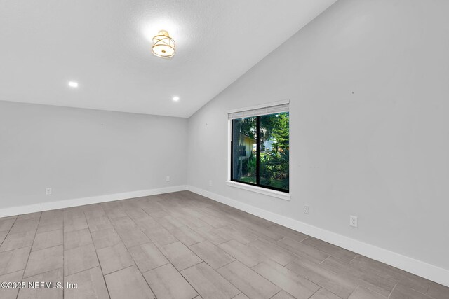 2032 Sandpiper Pt, Neptune Beach, FL 32266 - empty room with vaulted ceiling and recessed lighting