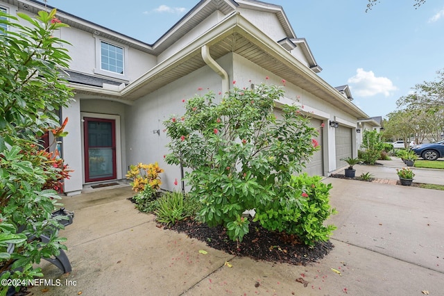 165 Amistad Dr, Saint Augustine, FL 32086 - property entrance with stucco siding, an attached garage, and driveway