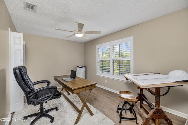 office featuring wood finished floors, baseboards, a textured ceiling, and a ceiling fan