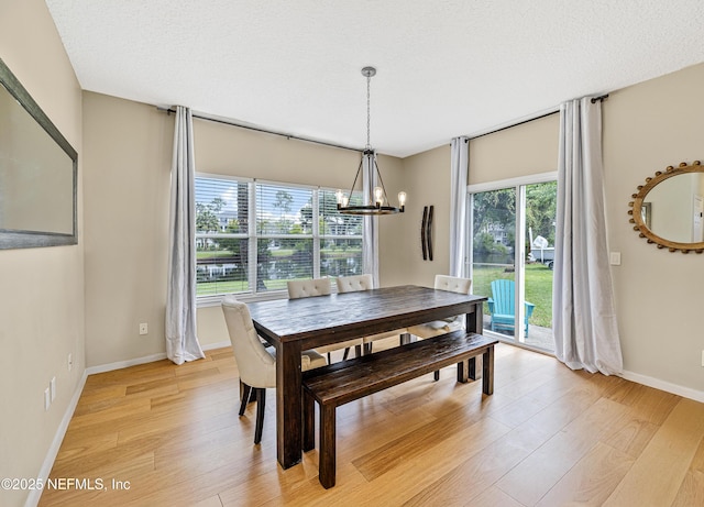 dining space with a chandelier, light wood-style floors, and baseboards