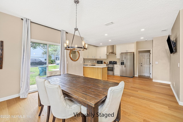 dining room featuring a chandelier, light wood finished floors, baseboards, a textured ceiling, and recessed lighting