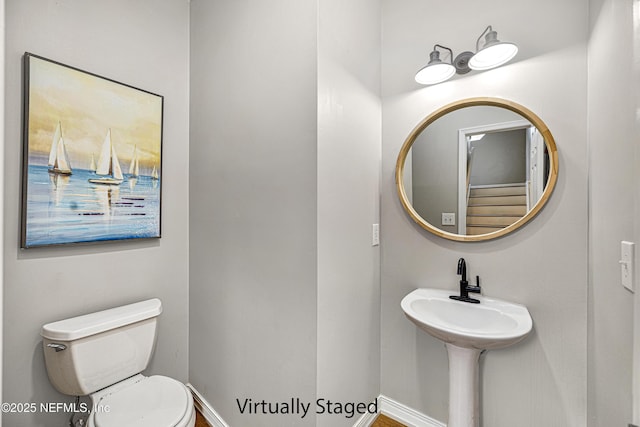 half bathroom featuring toilet and baseboards