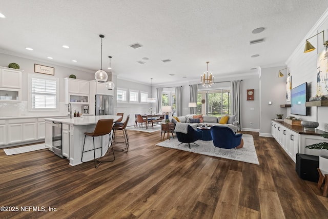 131 Seabrook Dr, Ponte Vedra, FL 32081 - kitchen with stainless steel refrigerator with ice dispenser, dark wood-style flooring, ornamental molding, a kitchen island, and white cabinets