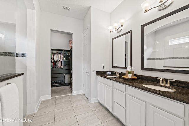 131 Seabrook Dr, Ponte Vedra, FL 32081 - full bathroom featuring double vanity, a spacious closet, walk in shower, tile patterned floors, and baseboards
