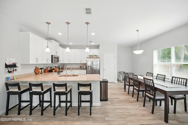 2483 Cortez Rd, Jacksonville, FL 32246 - kitchen with appliances with stainless steel finishes, a peninsula, a sink, white cabinetry, and light stone counters