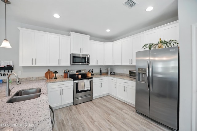 2483 Cortez Rd, Jacksonville, FL 32246 - kitchen featuring stainless steel appliances, a sink, white cabinetry, recessed lighting, and light stone countertops