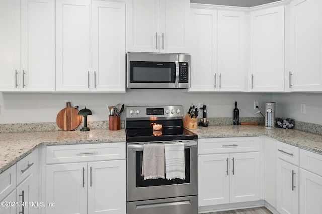 2483 Cortez Rd, Jacksonville, FL 32246 - kitchen featuring stainless steel appliances, white cabinets, and light stone countertops