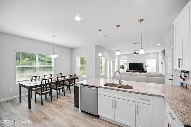 2483 Cortez Rd, Jacksonville, FL 32246 - kitchen featuring a sink, dishwasher, white cabinets, light wood finished floors, and light stone countertops