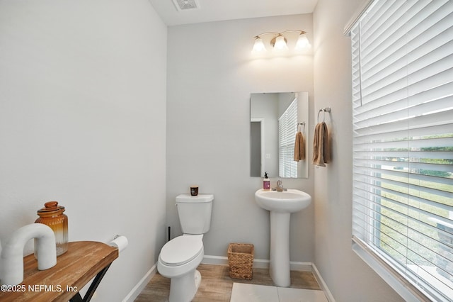 2483 Cortez Rd, Jacksonville, FL 32246 - half bath with toilet, baseboards, wood finished floors, and a sink