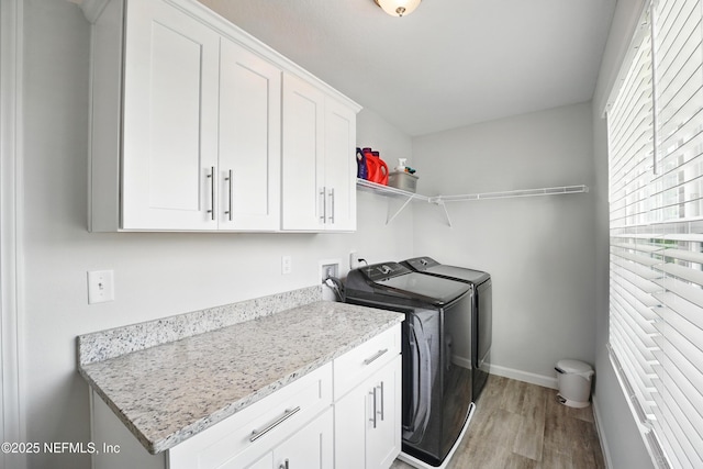 2483 Cortez Rd, Jacksonville, FL 32246 - washroom with cabinet space, washing machine and dryer, light wood-style flooring, and baseboards