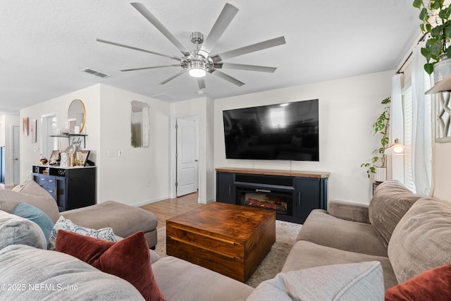 4328 Packer Meadow Way, Middleburg, FL 32068 - living area featuring a ceiling fan, a glass covered fireplace, wood finished floors, and baseboards