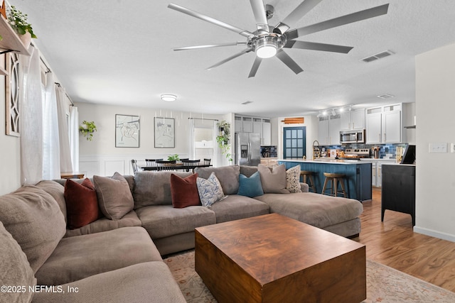 4328 Packer Meadow Way, Middleburg, FL 32068 - living area with a ceiling fan, light wood-style flooring, and a textured ceiling