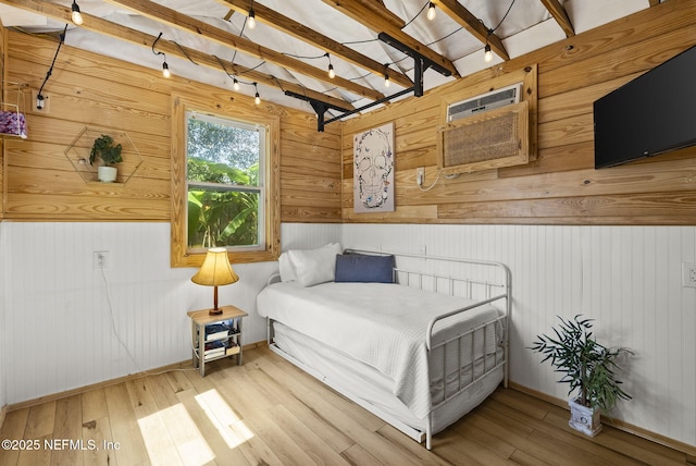206 Cabeza St, Saint Augustine, FL 32080 - bedroom featuring wood walls, wood finished floors, beamed ceiling, a wall mounted air conditioner, and baseboards