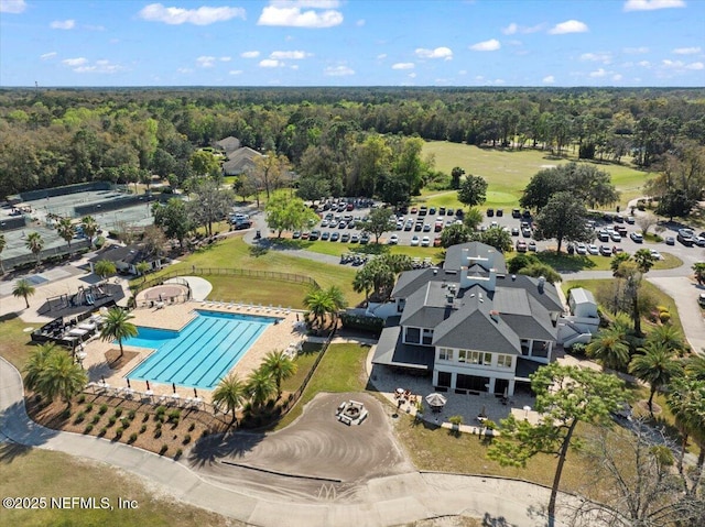 drone / aerial view of a forest and a pool area