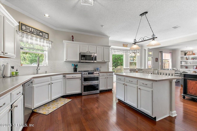 11921 Loretto Square Dr S, Jacksonville, FL 32223 - kitchen featuring stainless steel appliances, a textured ceiling, white cabinets, dark wood-type flooring, and crown molding
