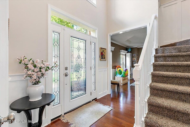 11921 Loretto Square Dr S, Jacksonville, FL 32223 - foyer featuring stairs, a decorative wall, wainscoting, dark wood-style flooring, and a high ceiling