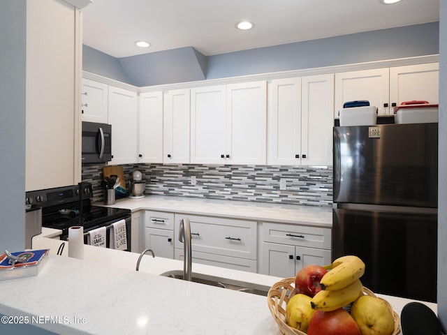 21126 NE 101st Ave, Melrose, FL 32666 - kitchen with black appliances, white cabinets, backsplash, recessed lighting, and light stone countertops