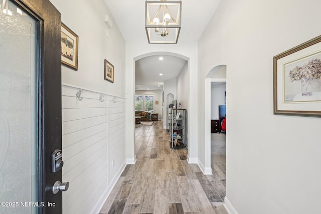 1009 Welaka Way, Saint Augustine, FL 32092 - hall featuring arched walkways, wood finished floors, a chandelier, and baseboards