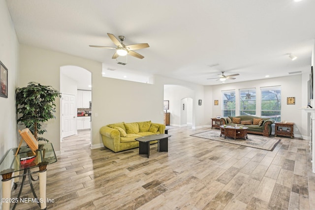 1009 Welaka Way, Saint Augustine, FL 32092 - living area featuring arched walkways, a ceiling fan, and light wood-style flooring